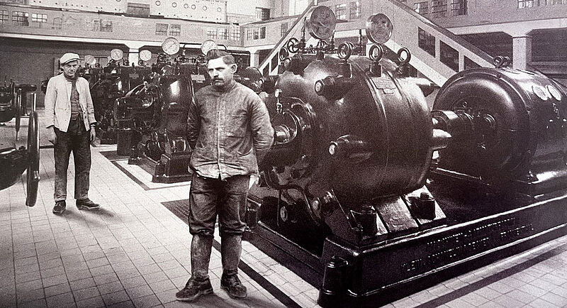 Große Pumpenanlage in einem Gebäude, zwei Männer stehen vor den Pumpen. Große Pumpenanlage in einem großen Gebäude, zwei Männer stehen vor den Pumpen.