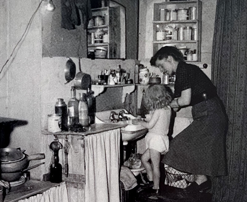 Eine Mutter mit Kind in einem Wohnraum mit einem integriertem Bad. Das Kind steht auf einem Hocker am Waschbecken. Eine Mutter mit Kind in einem Wohnraum mit einem integriertem Bad. Das Kind steht auf einem Hocker am Waschbecken.
