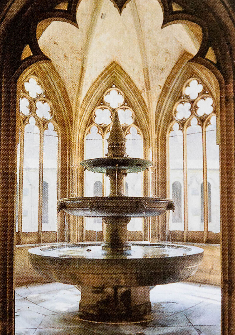 Brunnen mit drei Ebenen von Kirchenfenstern umsäumt Brunnen mit drei Ebenen von Kirchenfenstern umsäumt