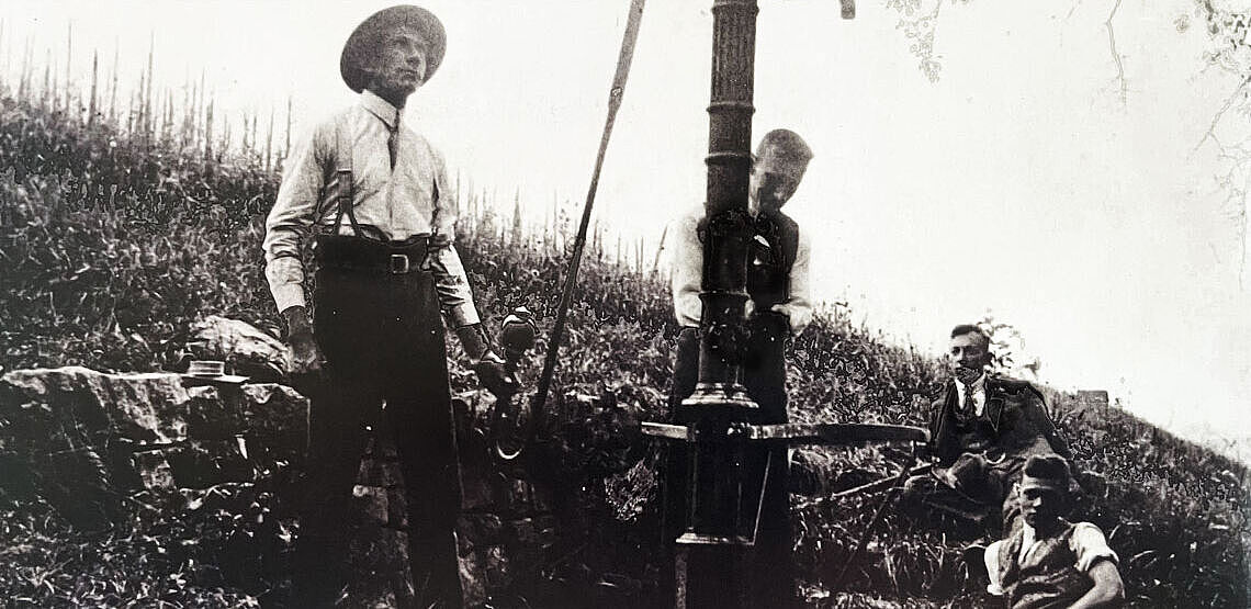 Vier Männer an einem Pumpbrunnen Vier Männer an einem Pumpbrunnen