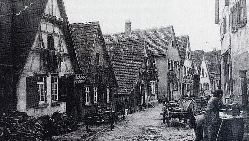 Altes Schwarz-Weiß-Foto zeigt eine Straße mit Fachwerkhäusern. Altes Schwarz-Weiß-Foto zeigt eine Straße mit Fachwerkhäusern.