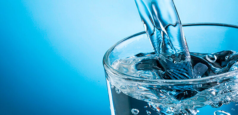 Wasser sprudelt in Wasserglas Wasser sprudelt in Wasserglas