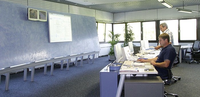 Deux employés à des postes de travail informatiques dans la salle de contrôle centrale de l'usine des eaux de Langenau.