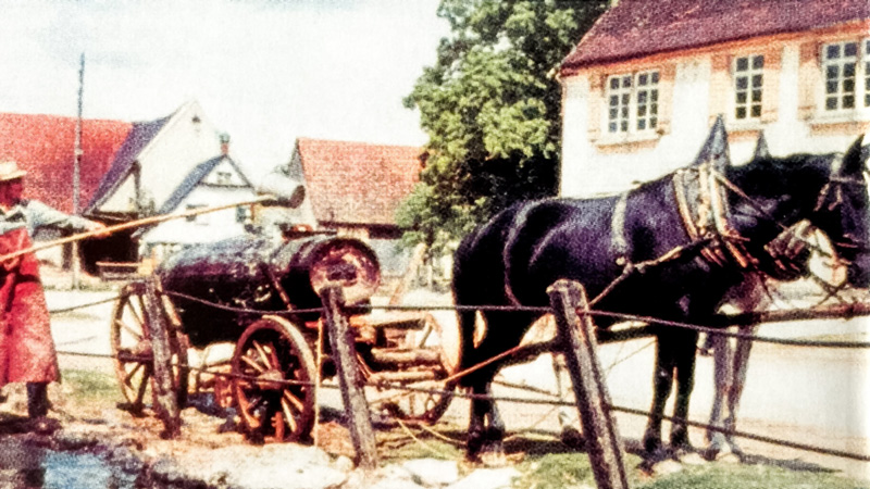 Mann schöpft wasser in einen großen Behälter auf einem Pferdefuhrwerk Mann schöpft wasser in einen großen Behälter auf einem Pferdefuhrwerk