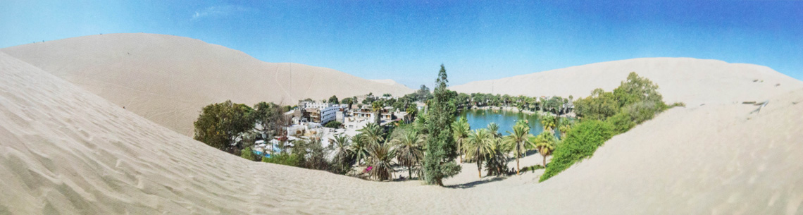 Eine Oase mitten in der Wüste mit einer Wasserstelle und grünen Bäumen Eine Oase mitten in der Wüste mit einer Wasserstelle und grünen Bäumen